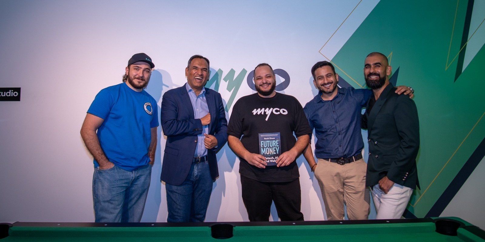 the myco and fumo teams posing together with a copy of the book in front of the myco logo